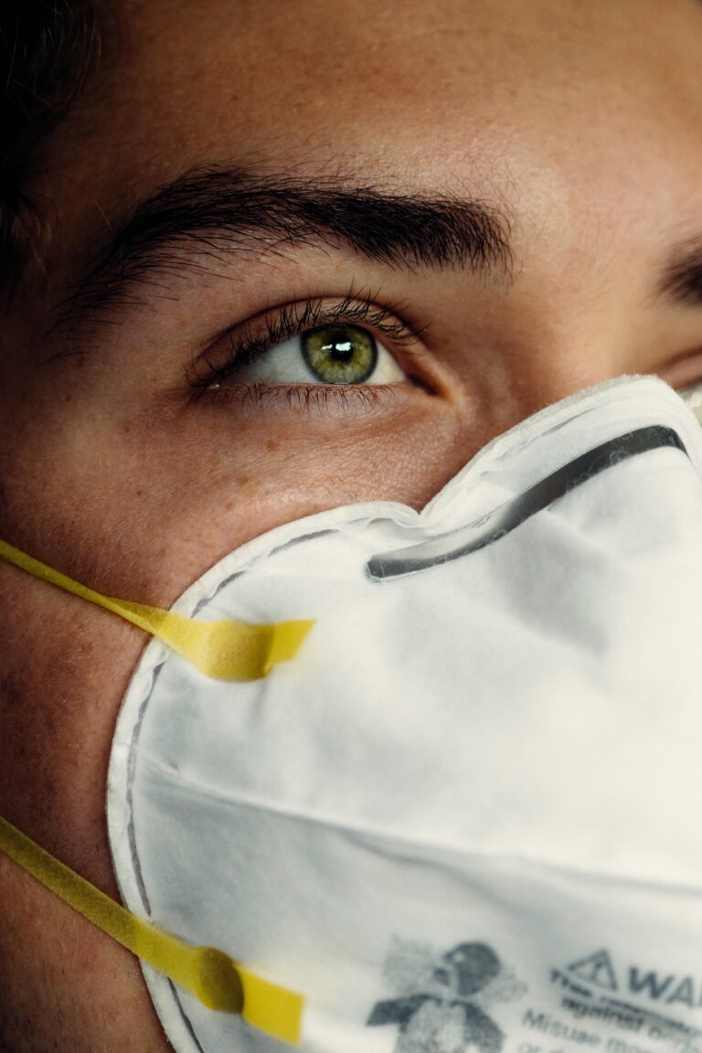 Detailed image of a person's eye and protective face mask, representing health safety.