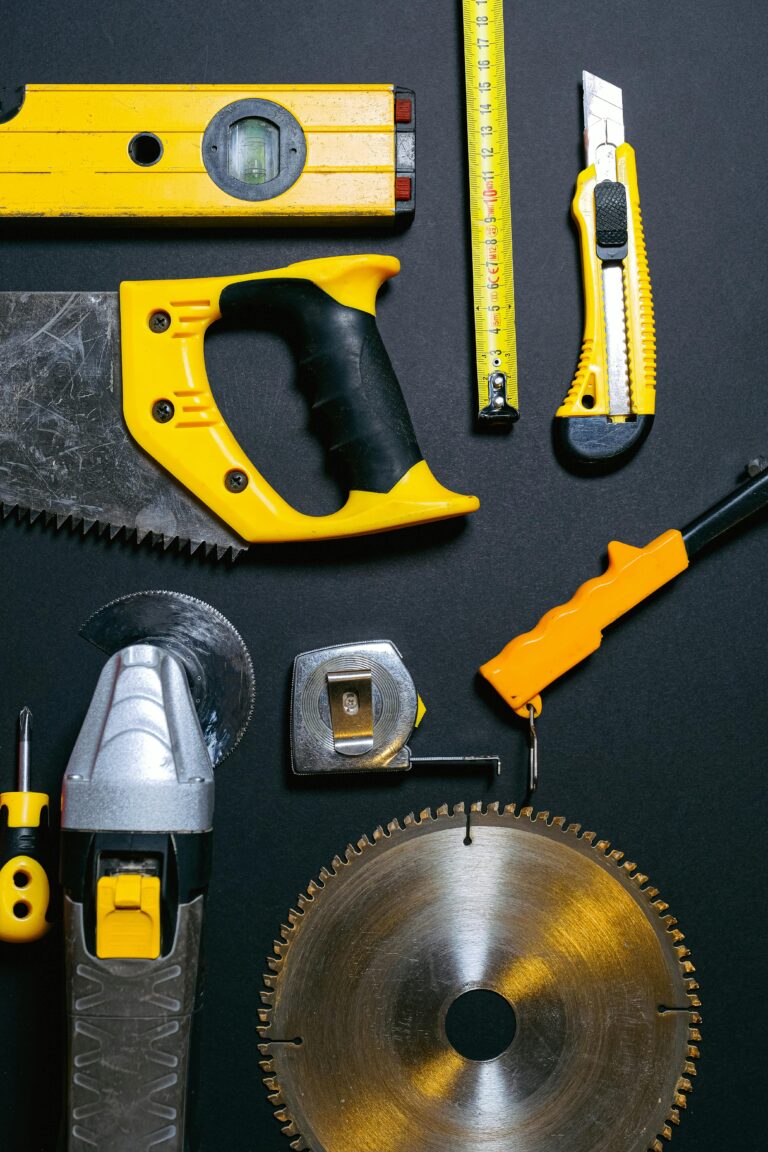 A collection of yellow and black construction tools arranged on a dark flat surface, ideal for DIY projects.